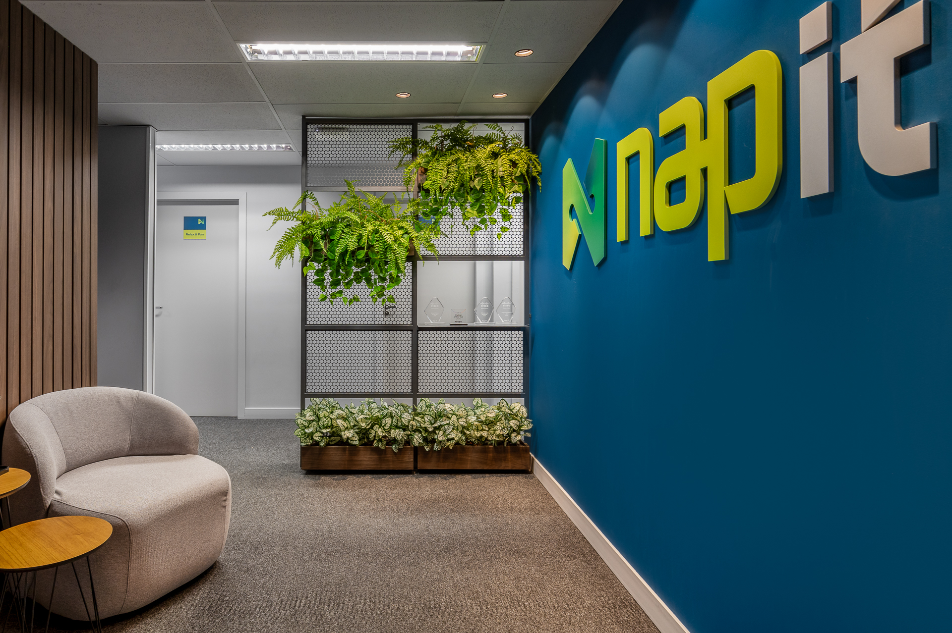 Escritório corporativo moderno com estações de trabalho e divisórias de vidro, paleta neutra e verde-sálvia, iluminação natural difusa, fotografia arquitetônica ultra-realista